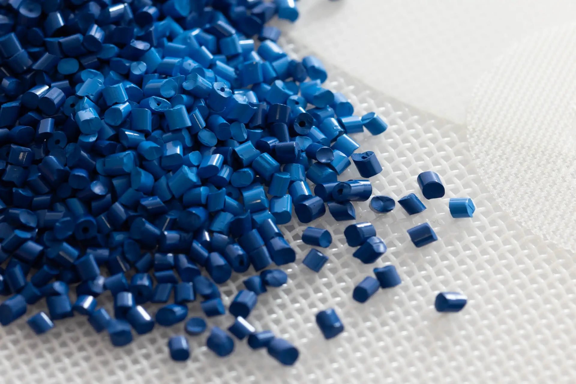 Blue polymer granules on white filter mesh